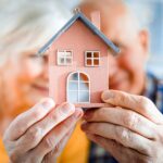 Un couple avec une mini maison dans les mains