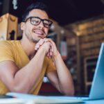 Un homme avec des lunettes devant son PC