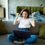 Une femme contente devant son PC